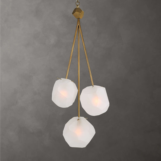 A three-light pendant light fixture with frosted glass shades and a matte antique brass finish.
