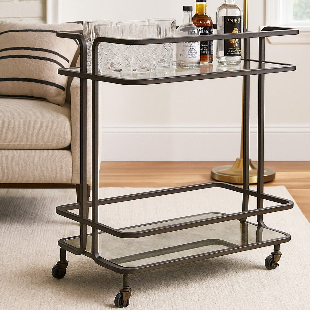 Bar cart with bottles on a rug in a room with a lamp and couch.