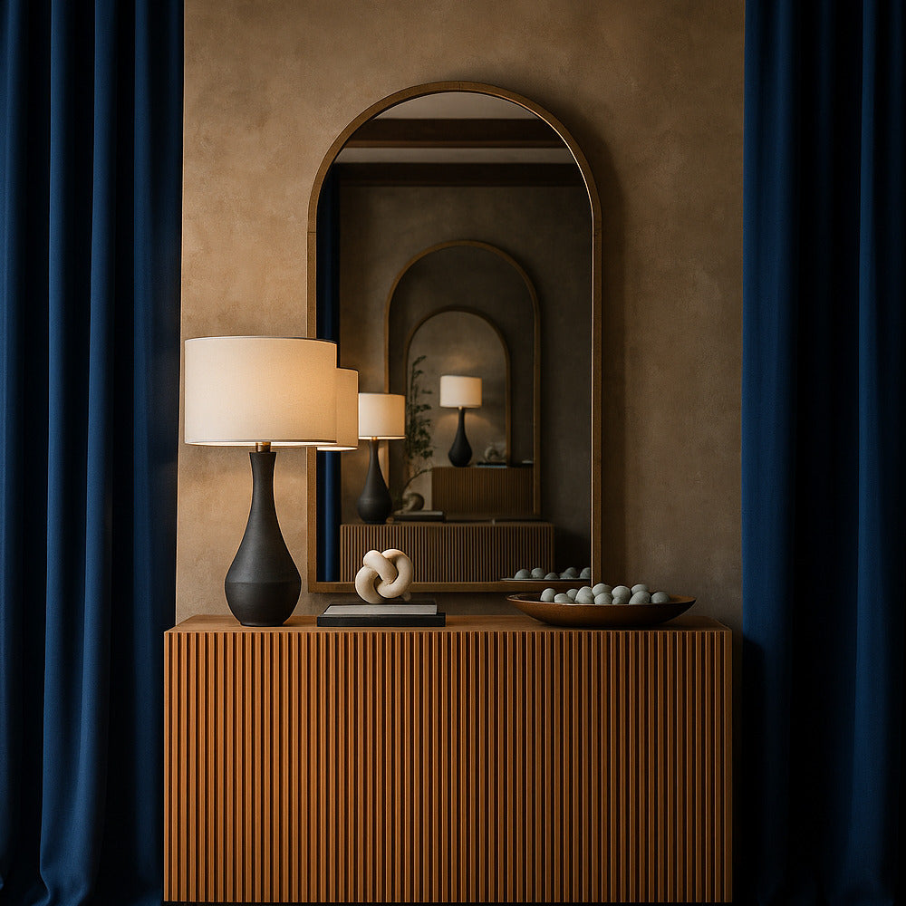 Wooden console table with decorative items against a brown wall with mirrors.