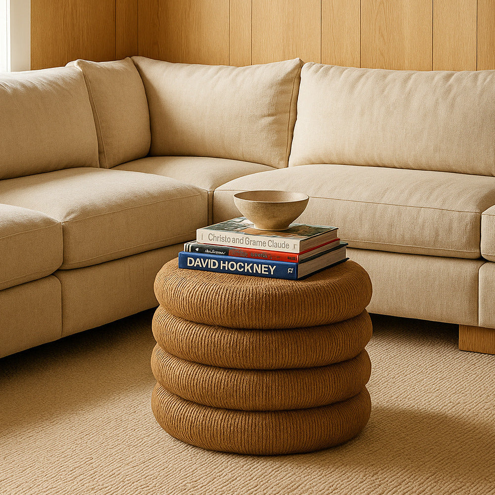 Beige sectional sofa in a room with wooden walls and a framed painting of a beach scene.