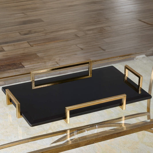 Black glass tray with gold handles on white countertop made with marble.
