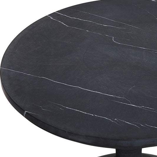 Black and white marble end table with geometric vase and decorative armchairs.