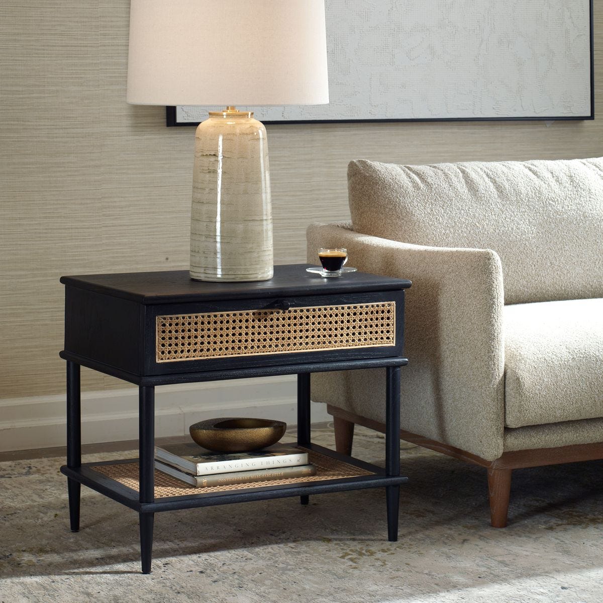 Black side table with woven drawer in a living room setting