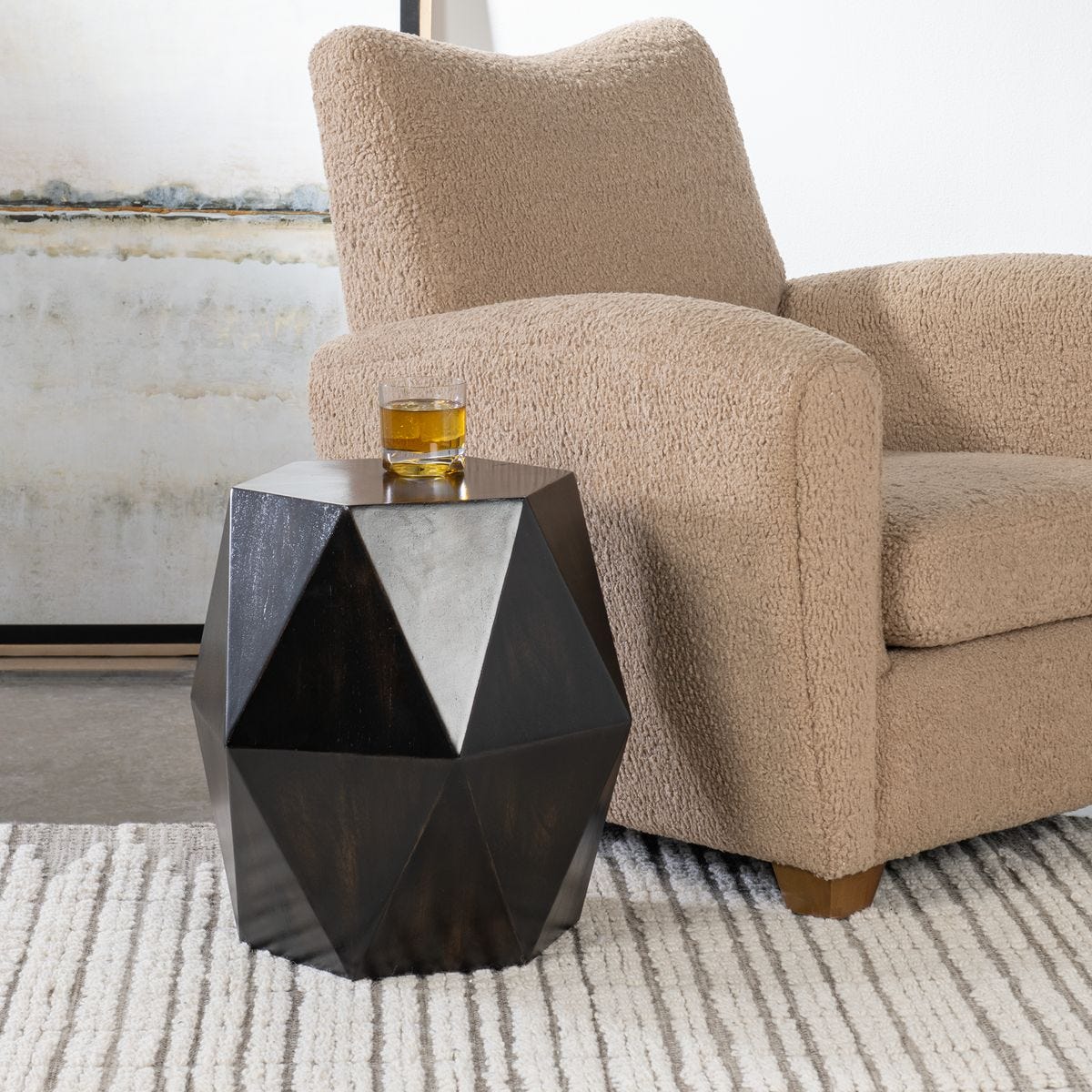 Modern living room with a geometric black side table and beige armchair.