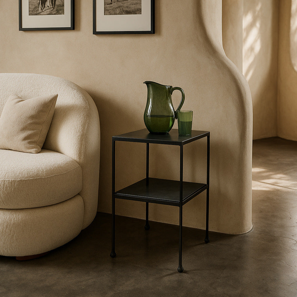 Living room with beige sofa, black side table, and framed pictures on the wall.