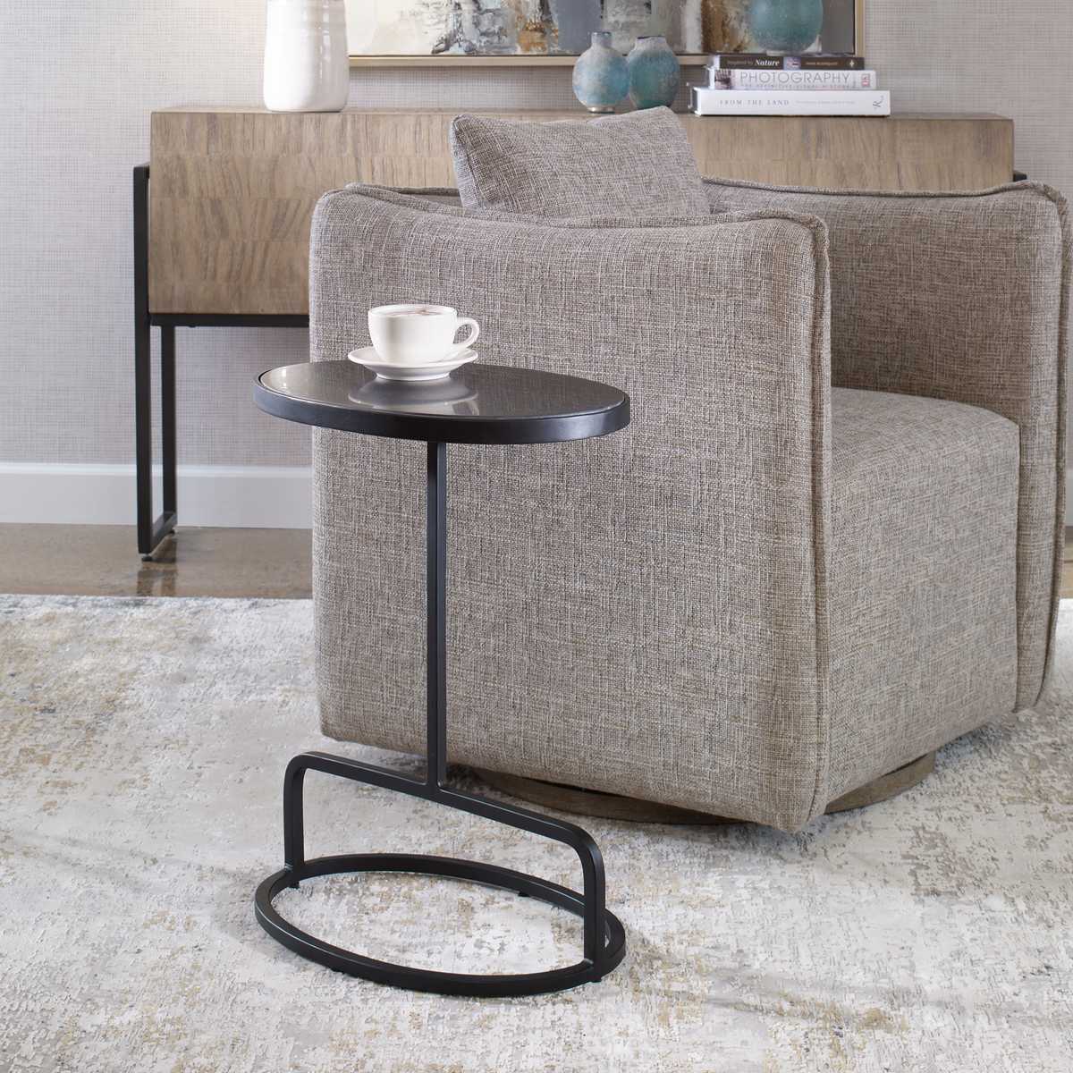 Gray armchair with a small black table in a room setting