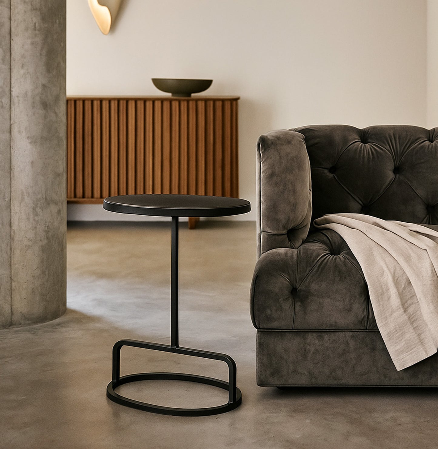 Modern living room with a gray sofa, black side table, and wooden cabinet.