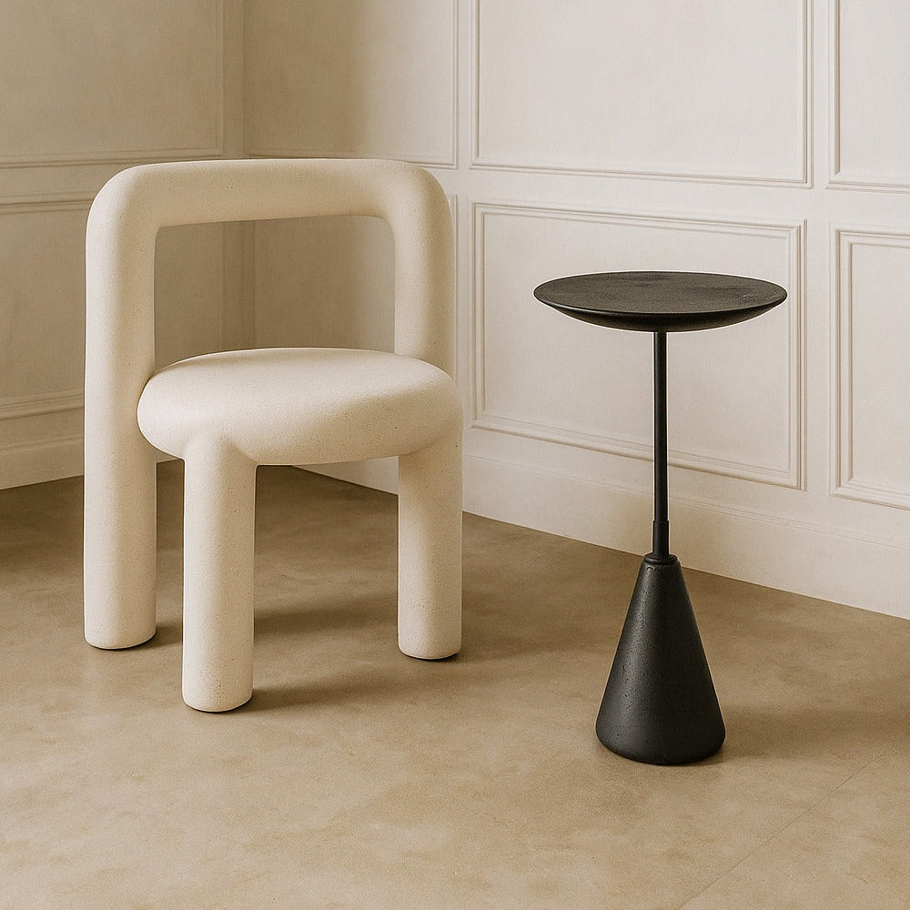 Beige chair and black side table against a beige wall