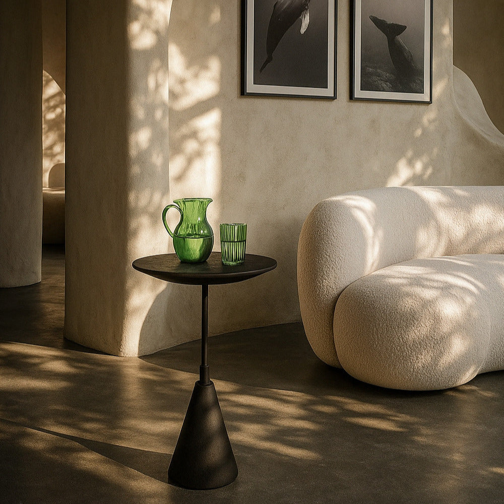 Modern interior with a side table, green vase, and framed artwork on a textured wall.