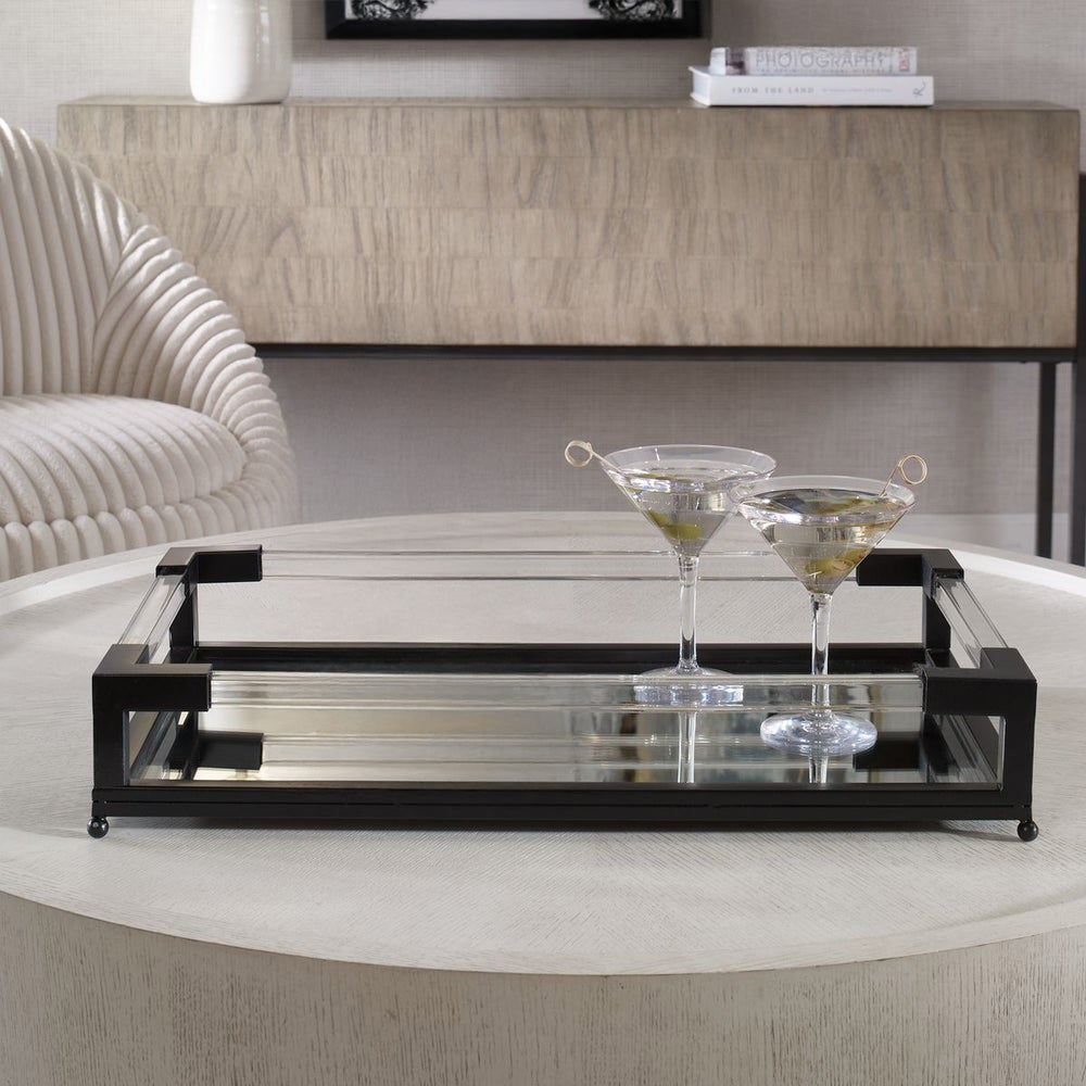 Black metal acrylic tray with mirrored bottom with martinis on a concrete coffee table.