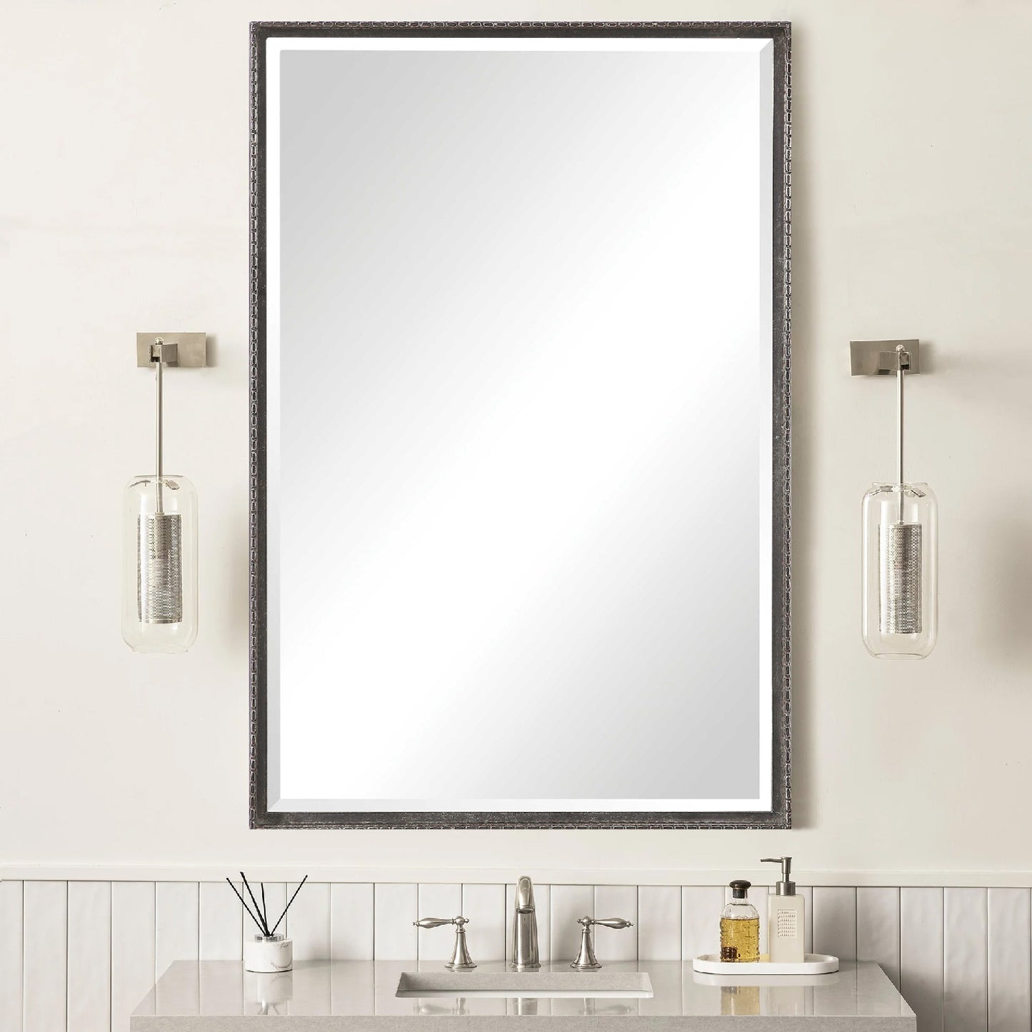 Black distressed rectangular vanity mirror above bathroom sink with granite counter.