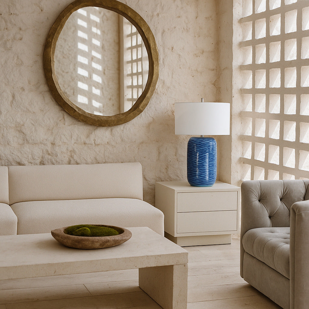 Modern living room with beige sofa, round mirror, and decorative lamp.