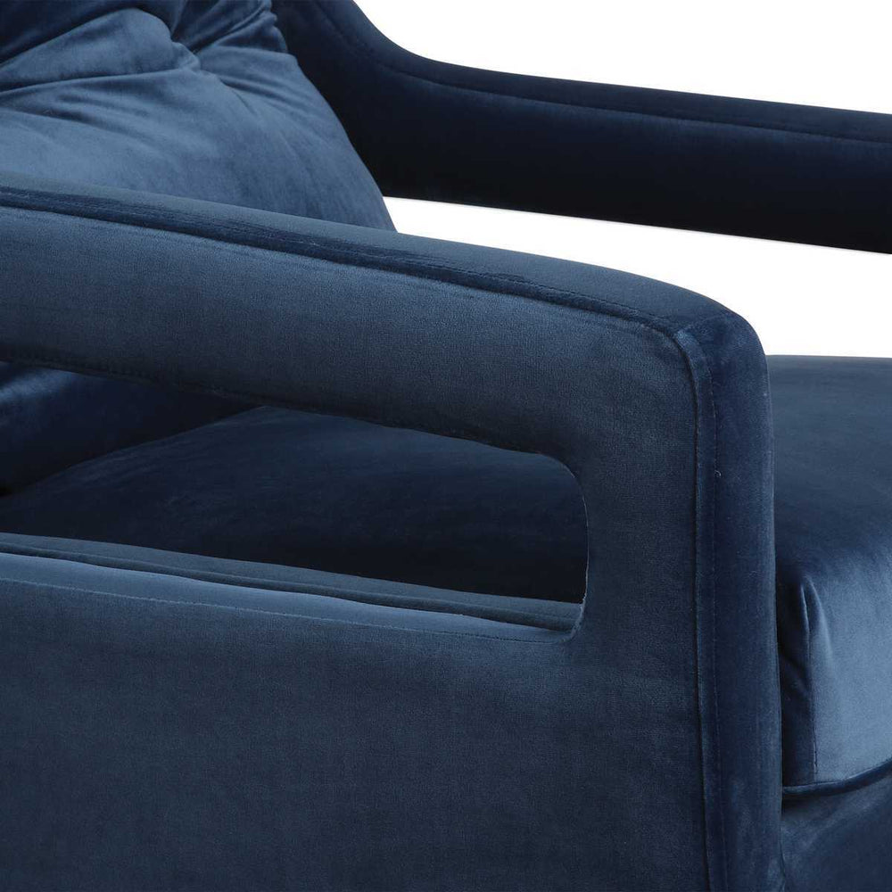 Close-up of a blue velvet armchair with a white background
