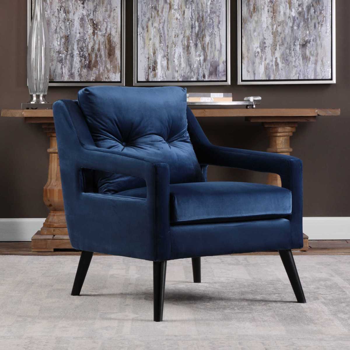 Blue armchair in a room with abstract art on the wall