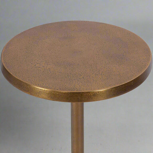Brass table in a modern living room with white decorative chair.