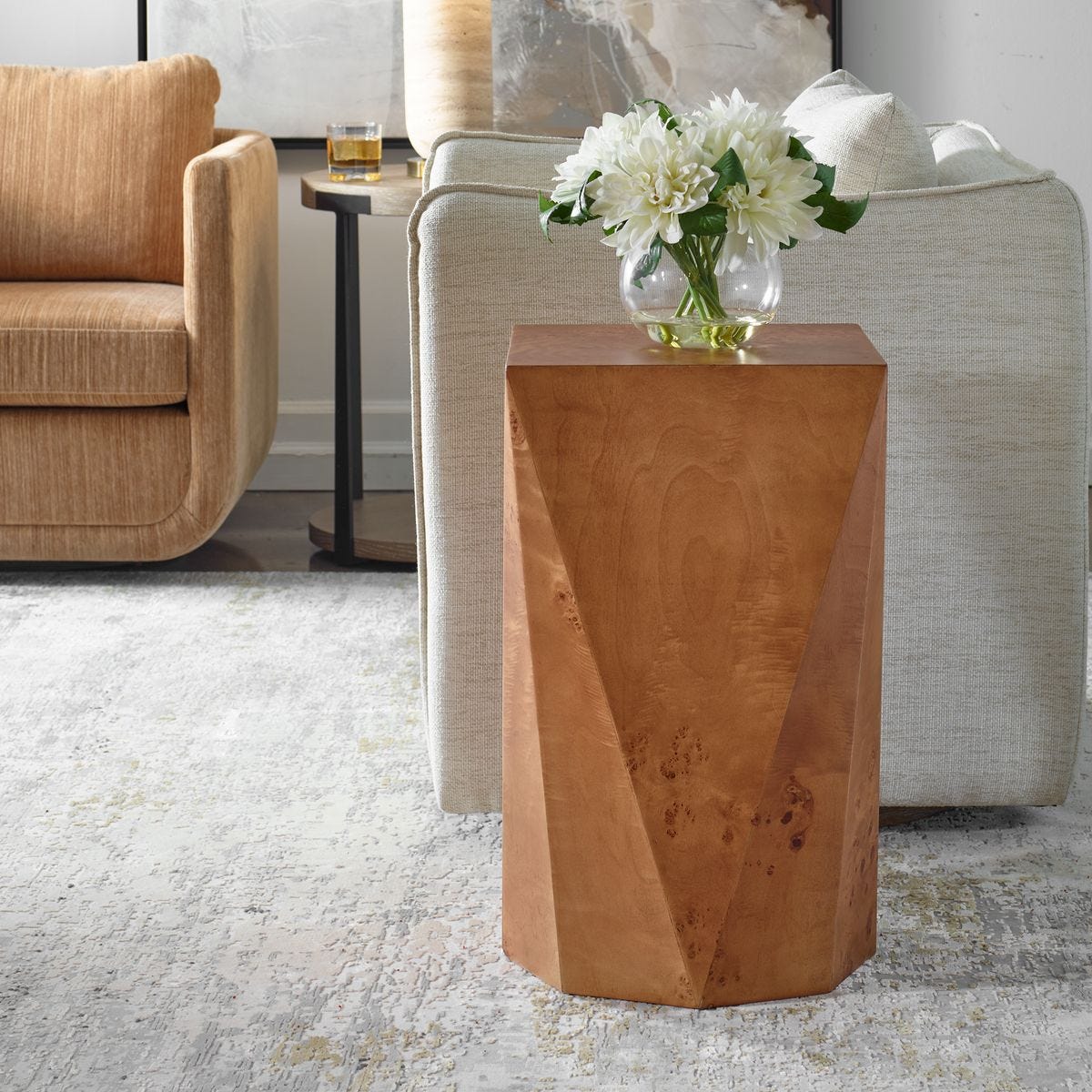Wooden side table with a vase of white flowers in a living room setting.