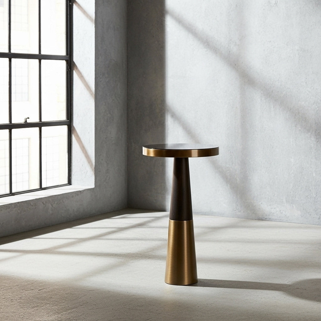 Bronze side table in a room with large windows and concrete walls.