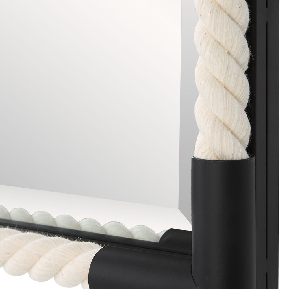 Corner of the black iron frame of the mirror.