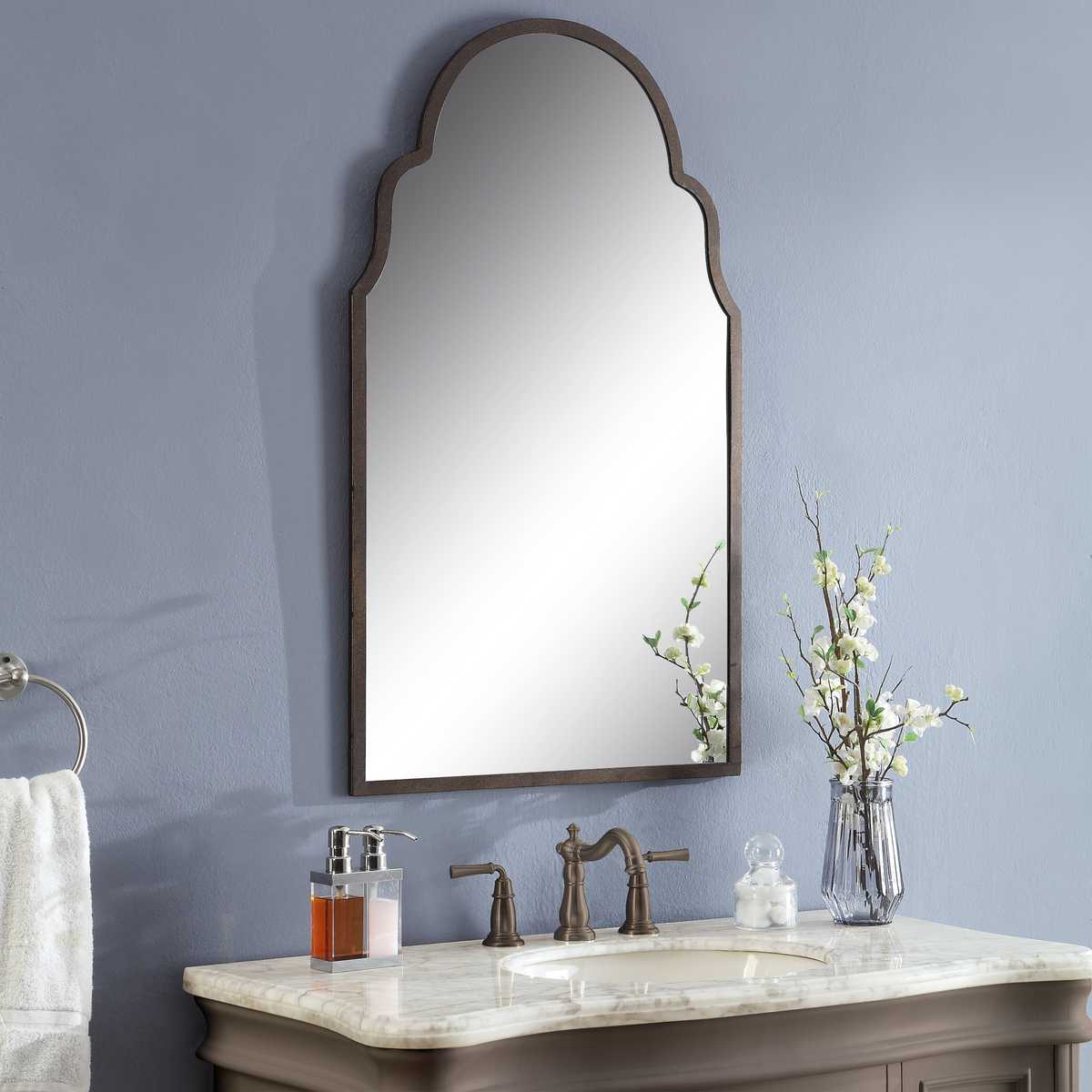 Bathroom vanity with mirror, sink, and decorative elements against a gray wall.