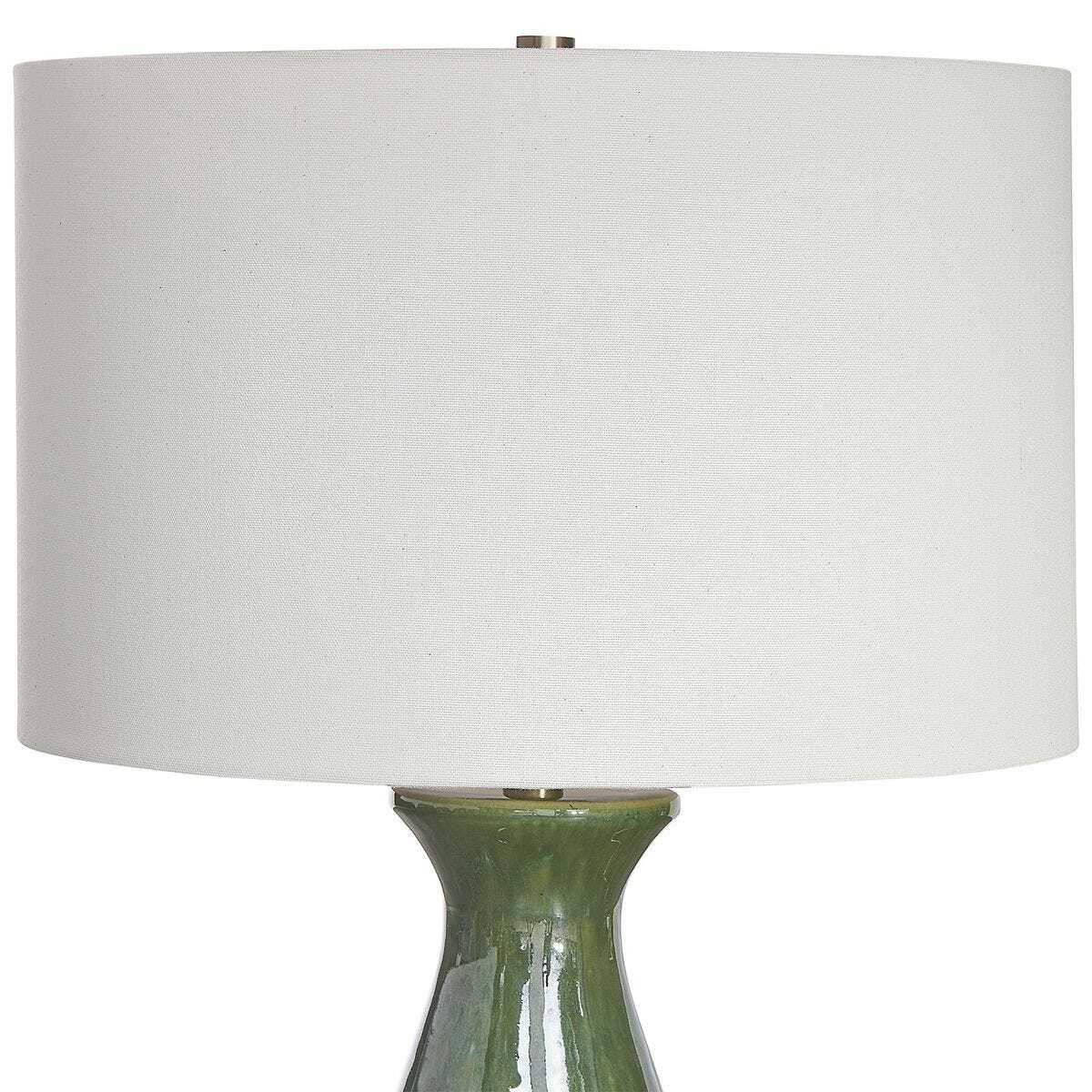 Table lamp with a green base and white shade on a white background
