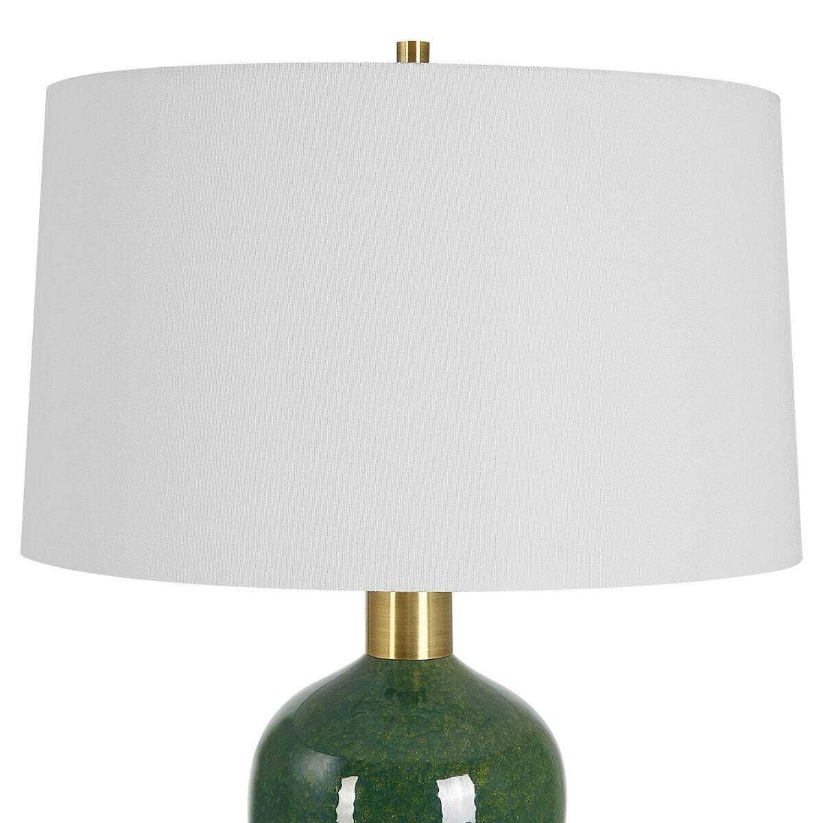 Table lamp with a green base and white shade on a white background