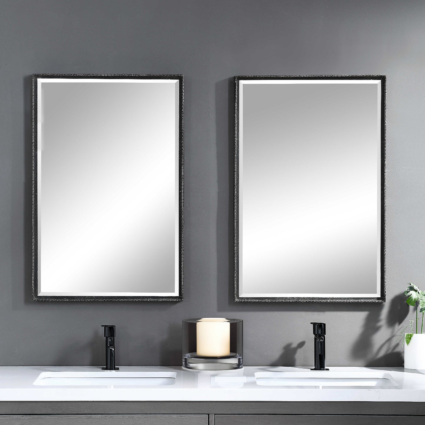 Distressed his and her black rectangular mirrors in a modern bathroom.
