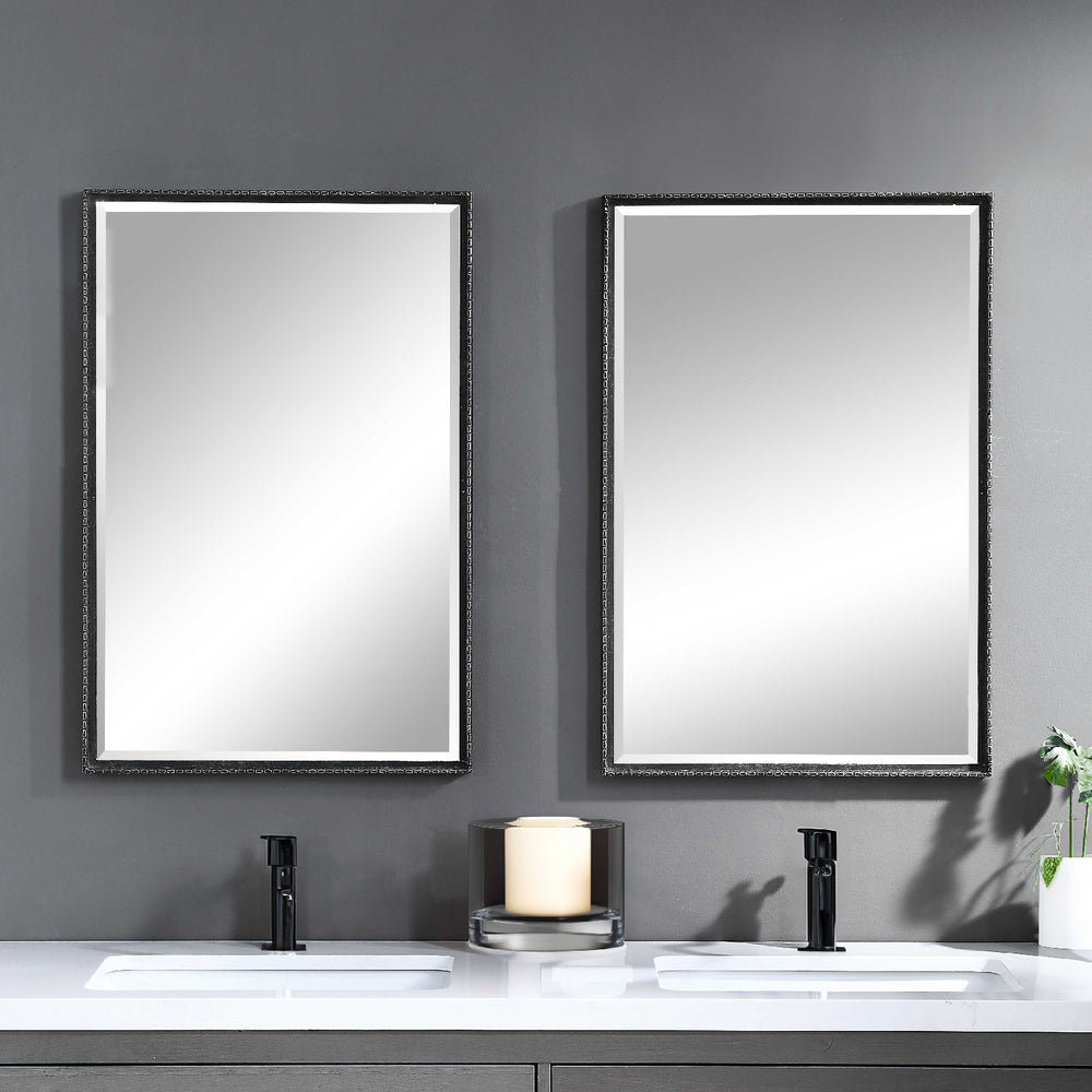Distressed his and her black rectangular mirrors in a modern bathroom.