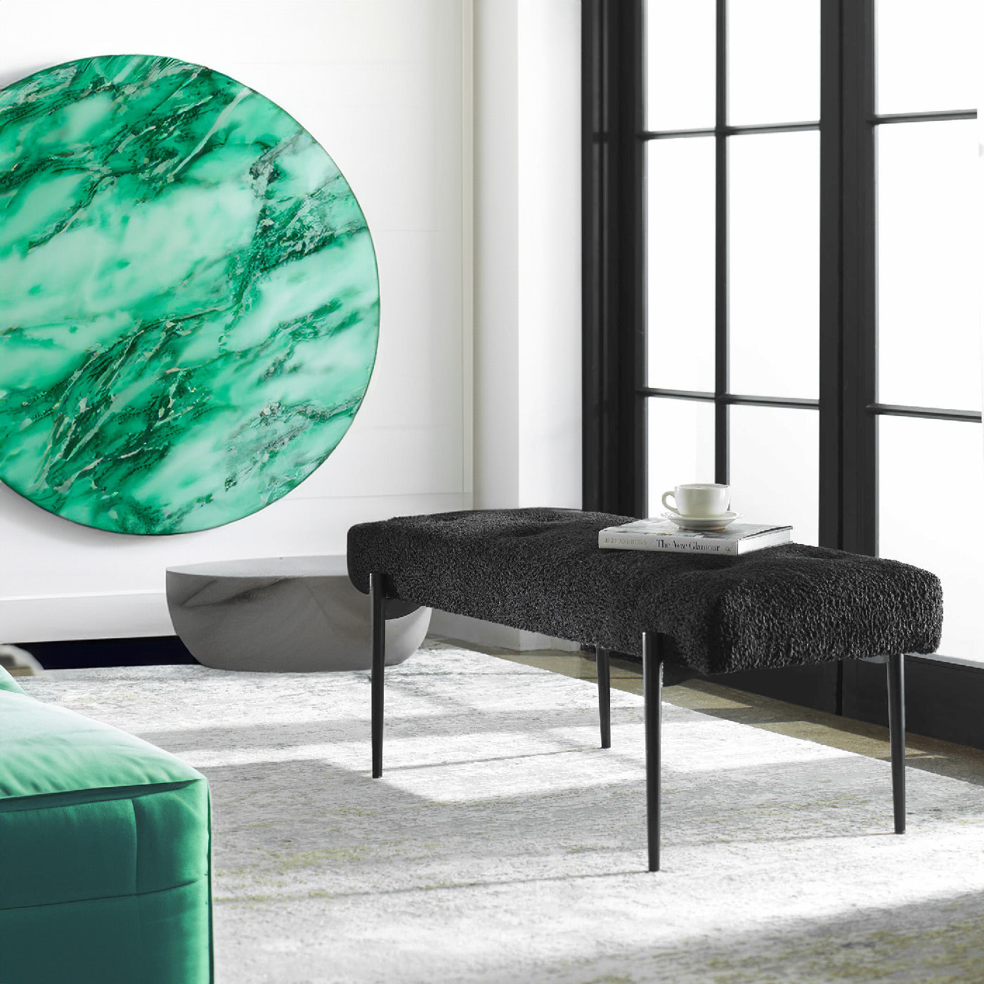 Black bench in an eclectic living room with emerald green accents.