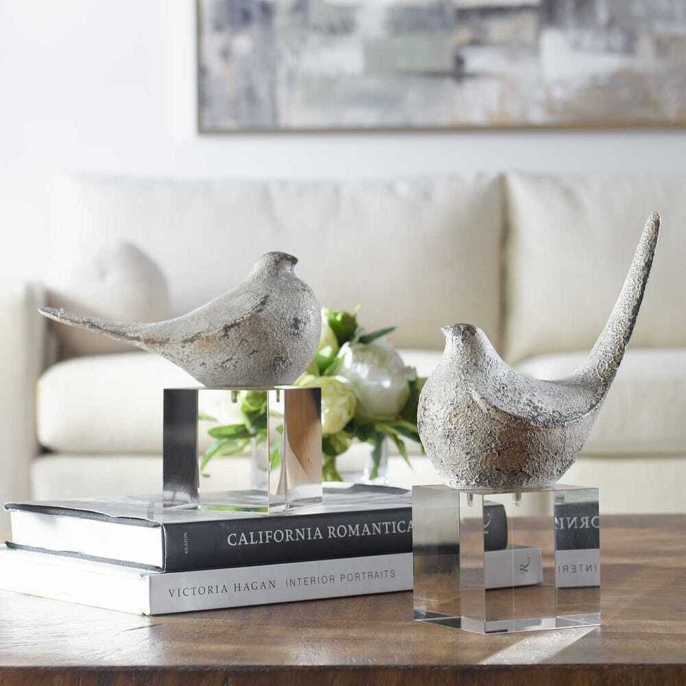 Decorative bird sculptures on books with a blurred background