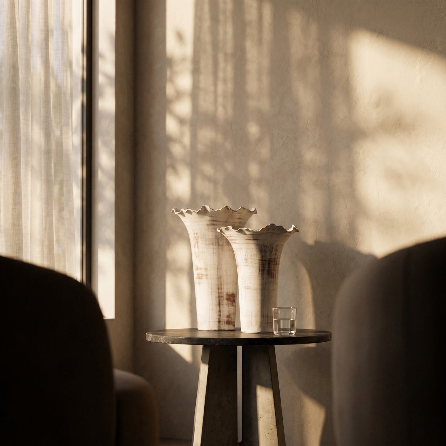 Two decorative vases on a small table with soft lighting and shadows.
