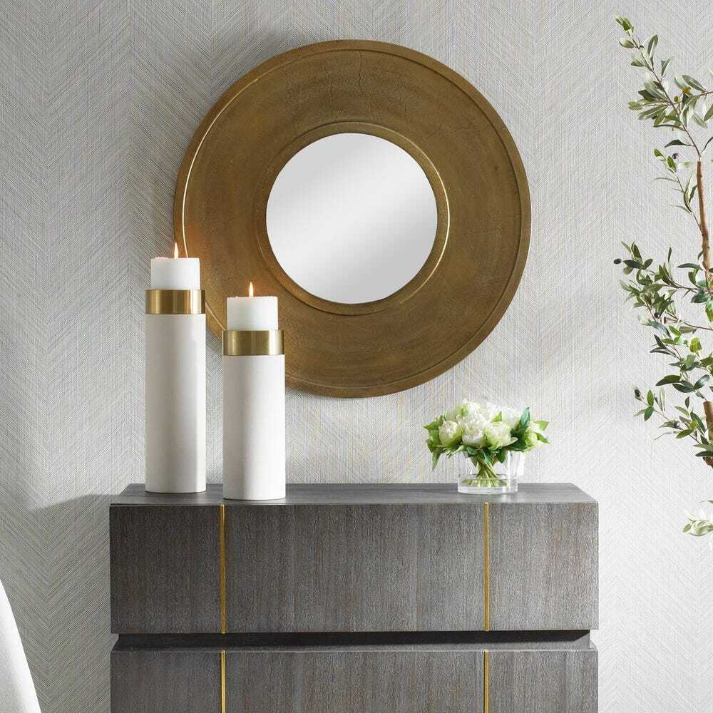 Decorative console table with candles and a mirror in a stylish interior setting