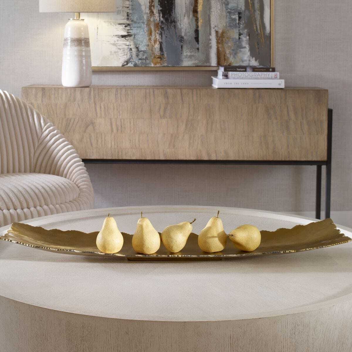 Decorative tray with pears on a table in a stylish interior setting.