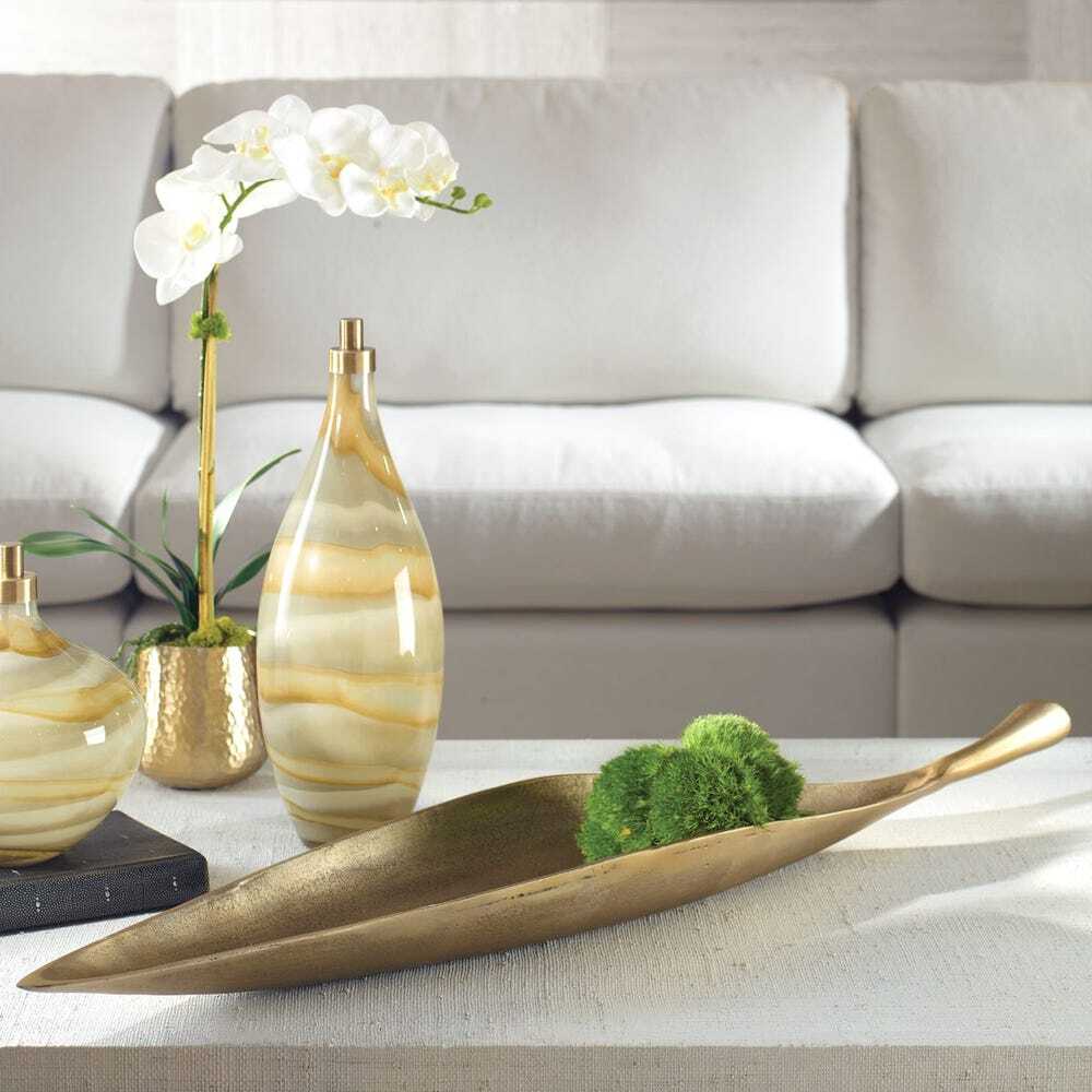 Gold metal leaf bowl tray on coffee table.