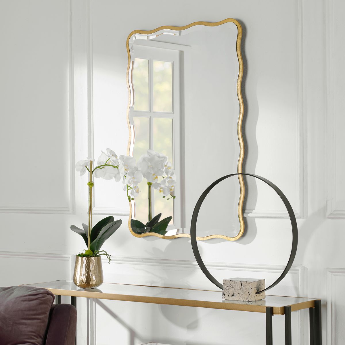 Gold scalloped mirror in white entryway.