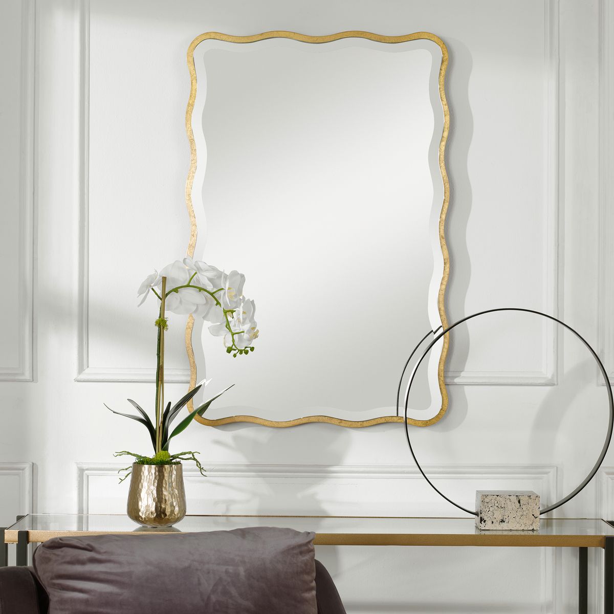 Gold scalloped mirror above console.