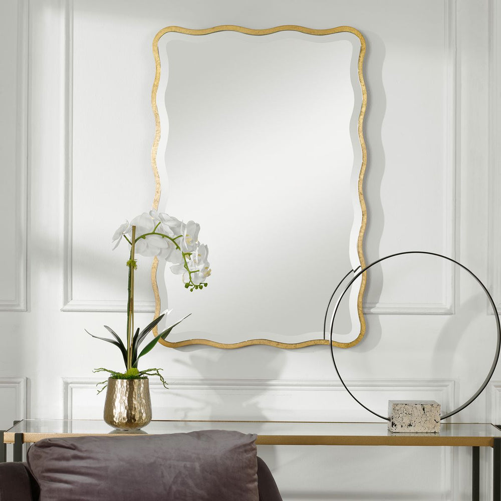Gold scalloped mirror above console.