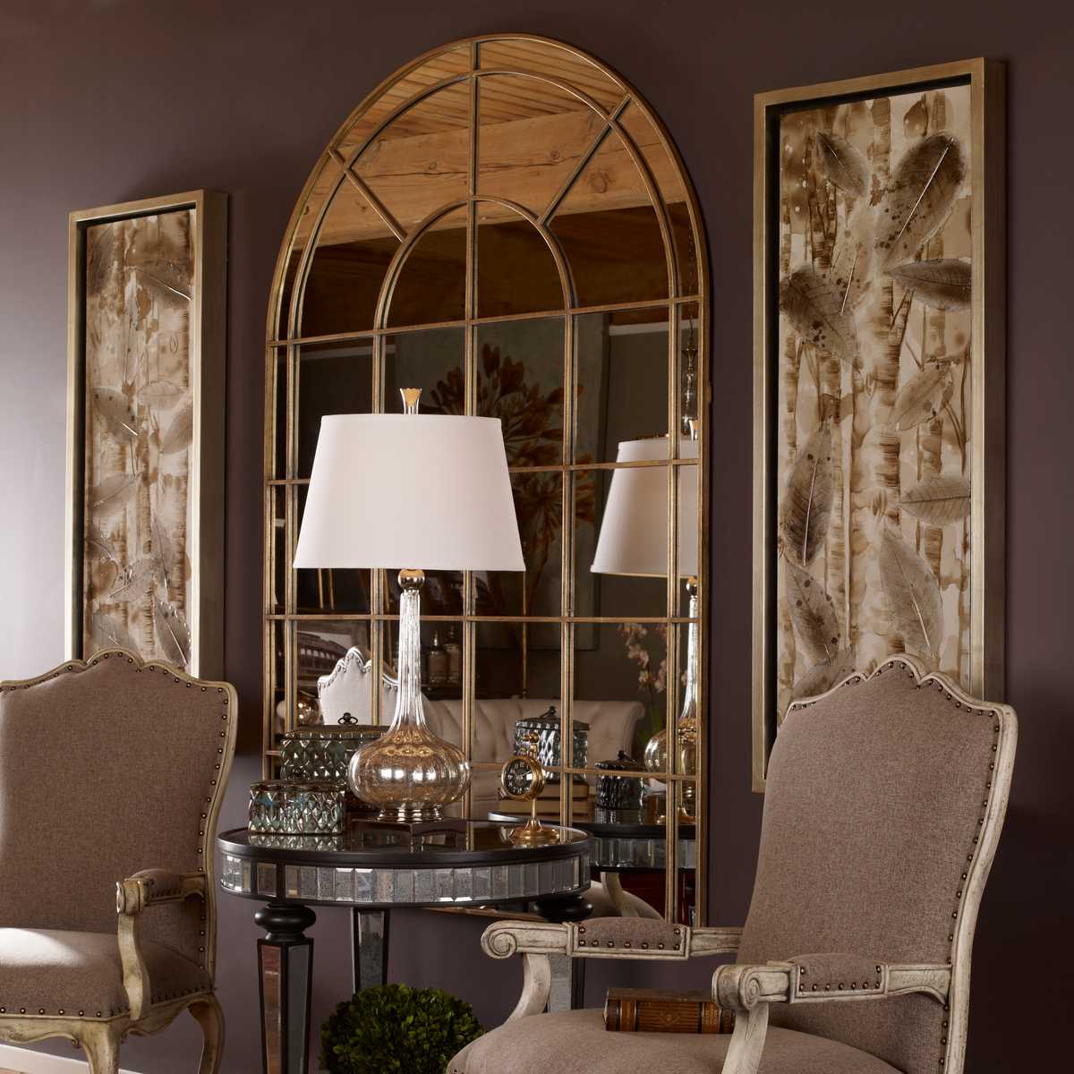 Decorative interior with large mirror, chairs, and table against a purple wall.