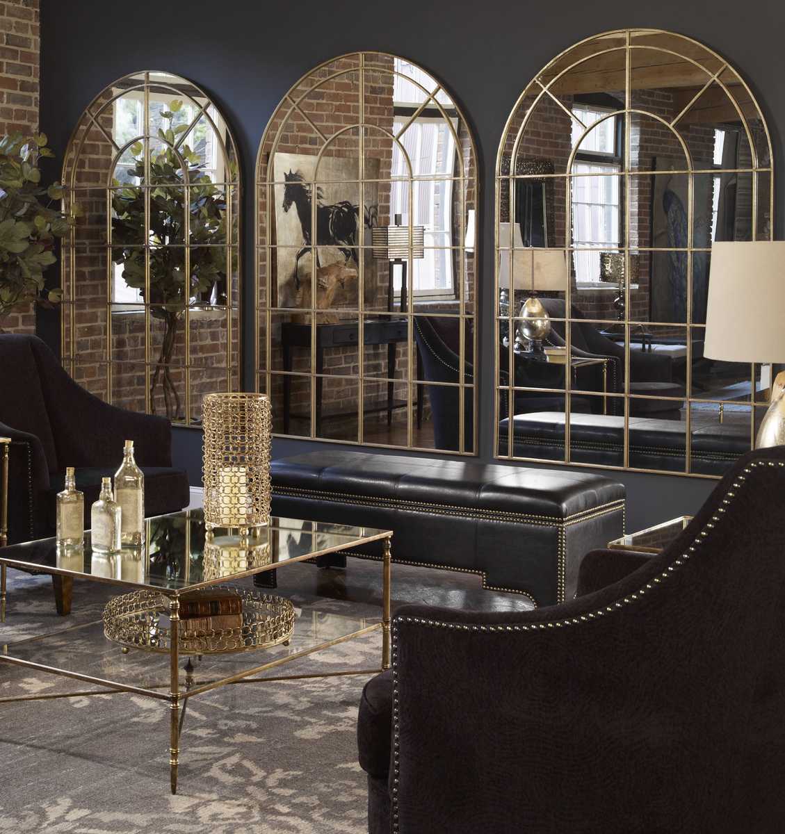 Luxurious living room with arched mirrors, dark furniture, and decorative items.