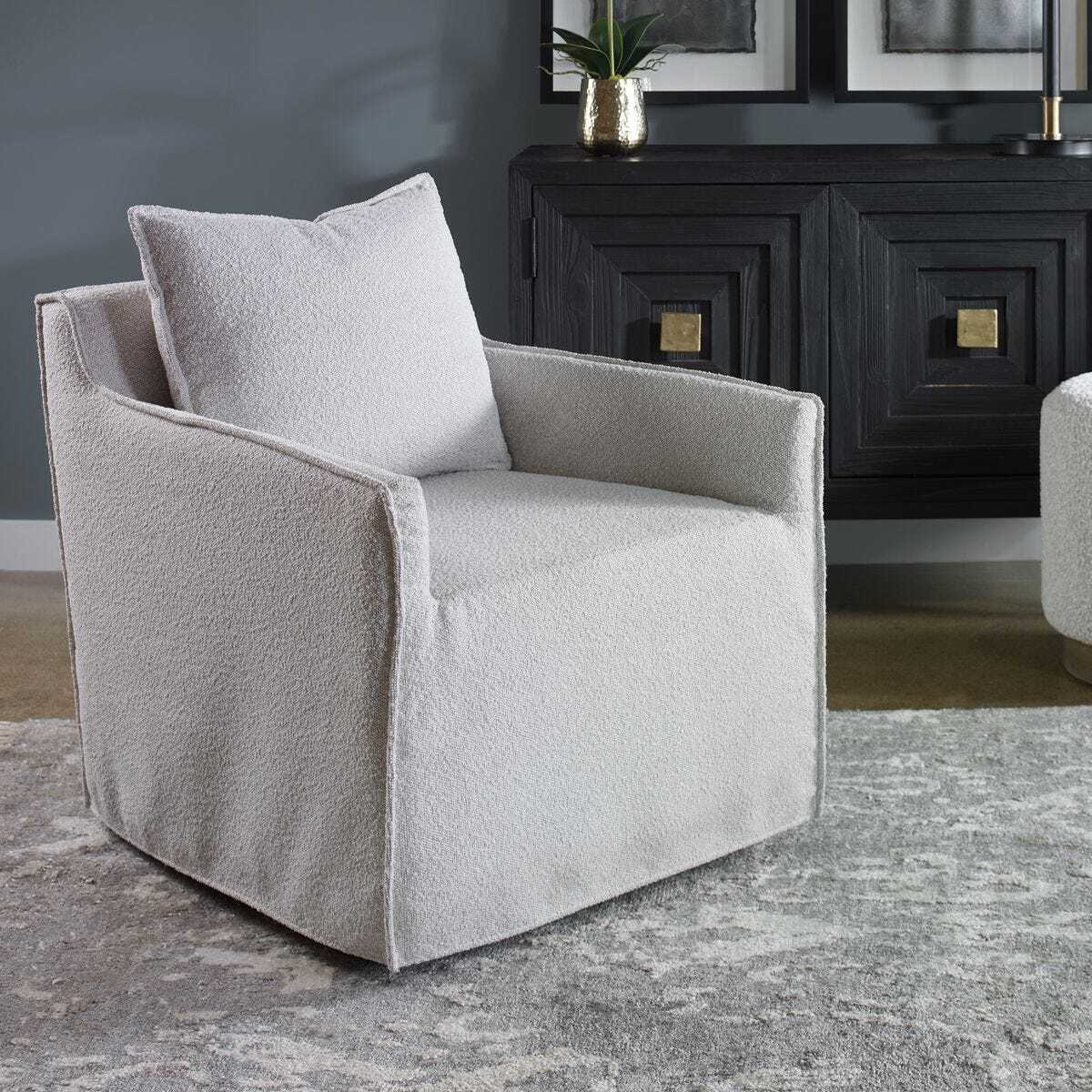 Gray armchair in a room with a dark cabinet and decorative items.