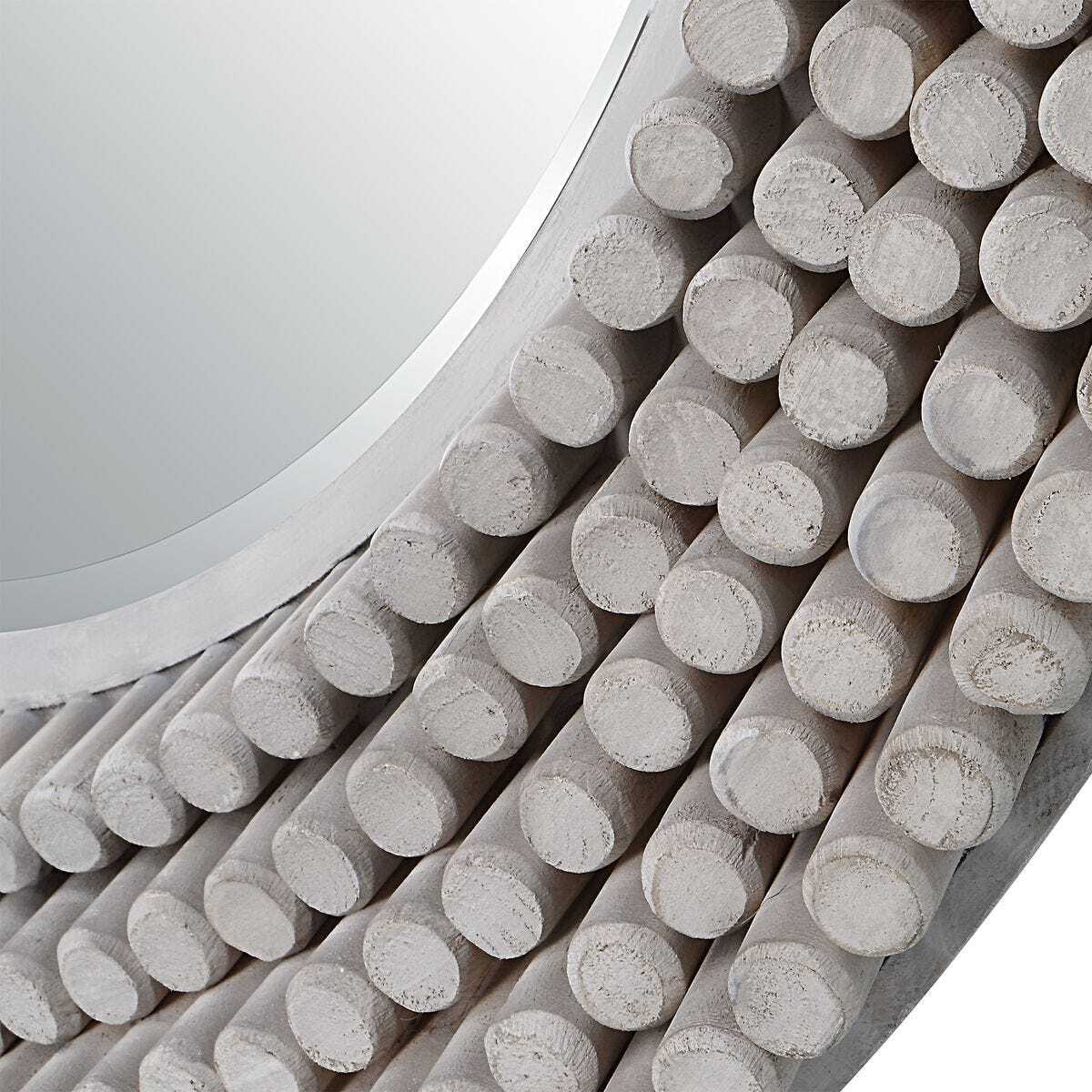 Close-up of a decorative wall mirror with cylindrical concrete-like design.