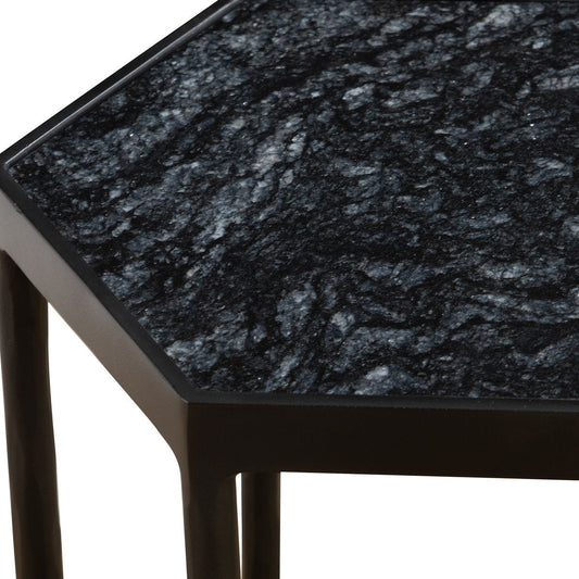 Beige textured sofa next to a black side table with a glass of whiskey on a patterned rug.