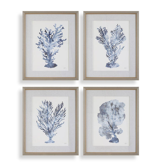 Four painting of blue coral wall art above a black wood console with gold knobs and a white coastal lamp.