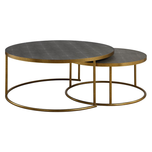 Set of two dark gray shagreen and brass nesting coffee tables in a modern living room.