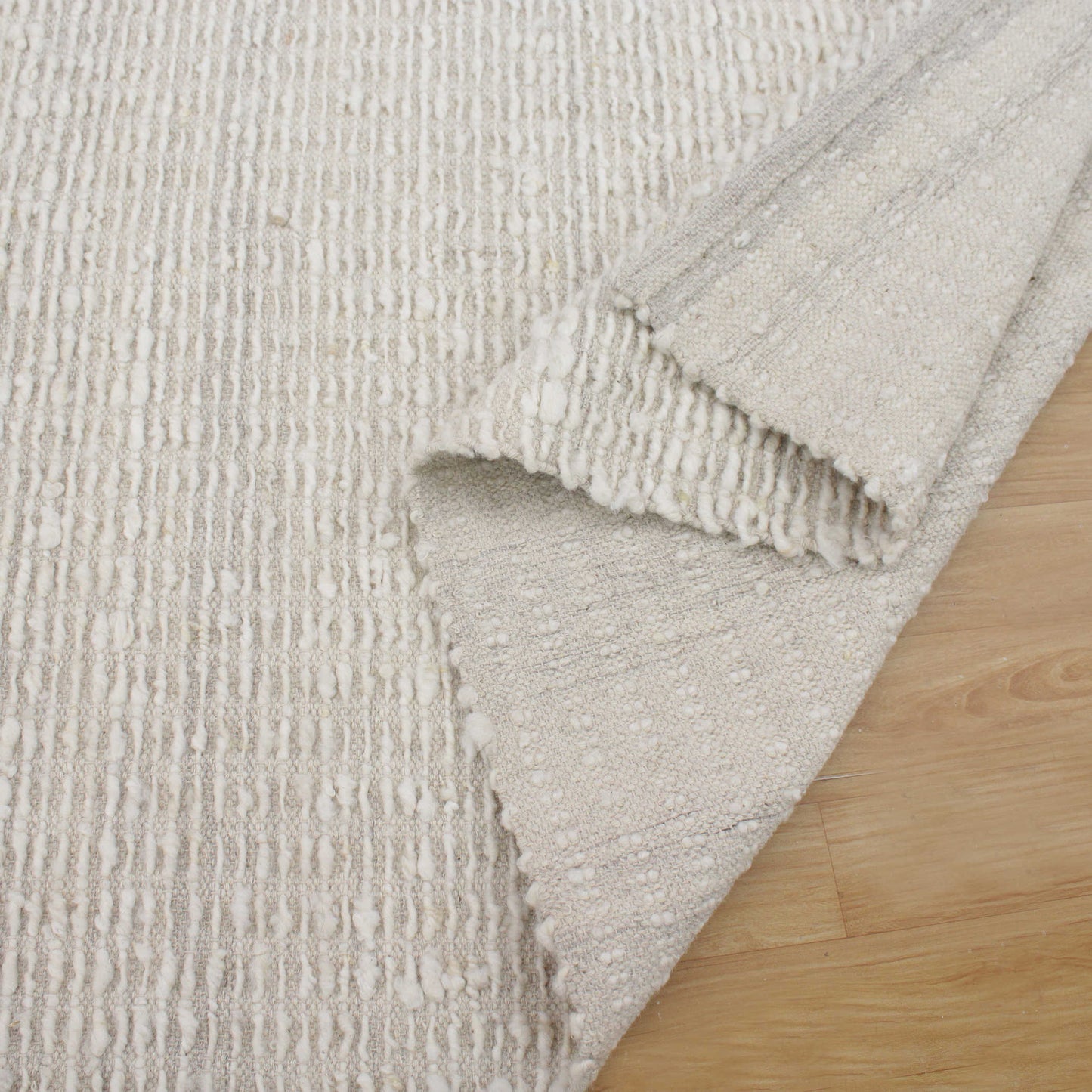 Ivory area rug folded up.