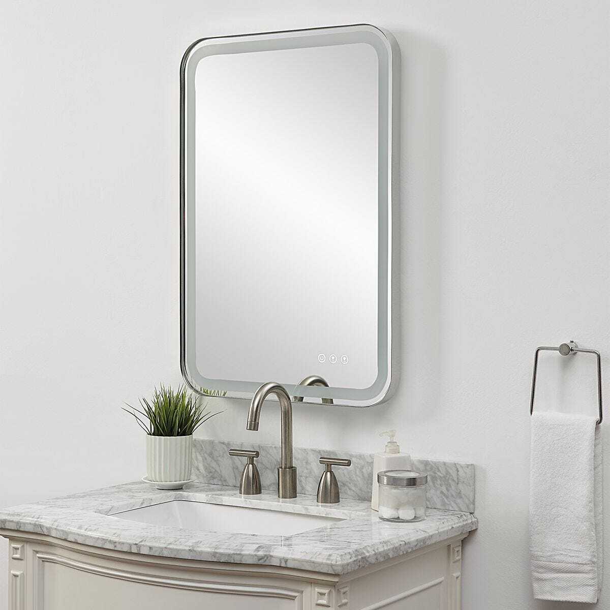 Angled polished nickel mirror above vanity.