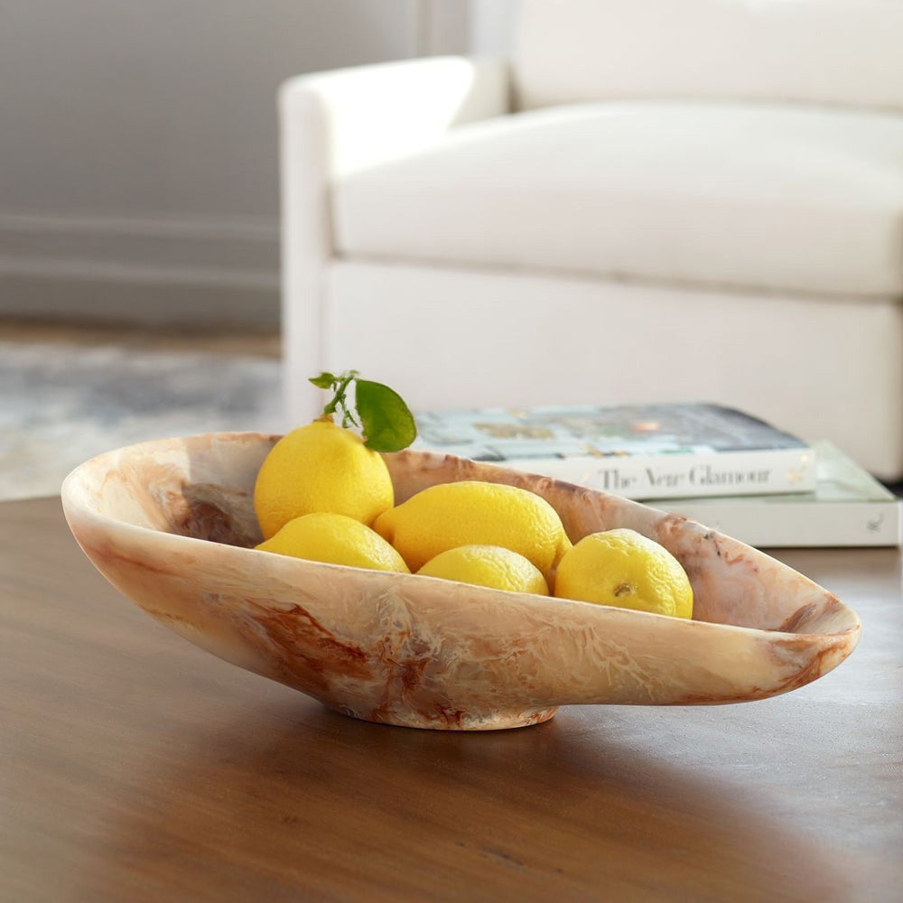 Marble bowl with lemons and coffee table books in a living room.