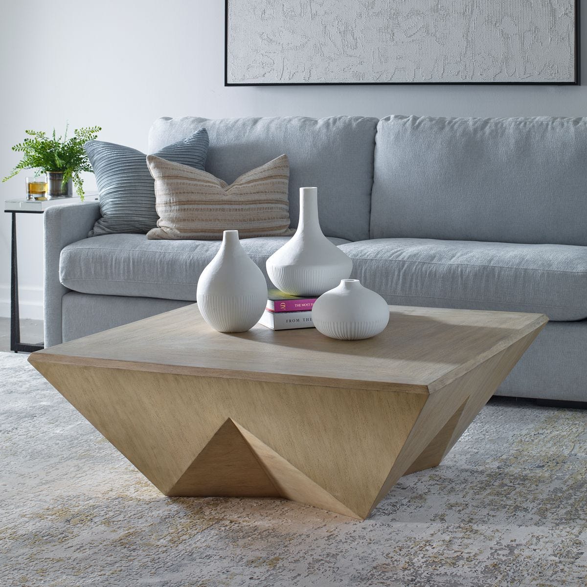 Modern living room with a geometric coffee table and decorative vases.