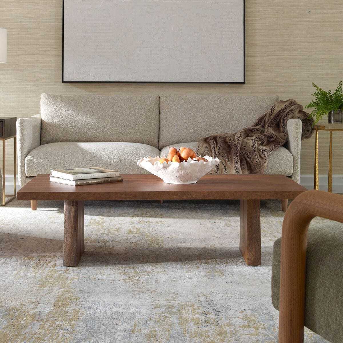 Living room with a beige sofa, wooden coffee table, and decorative items.