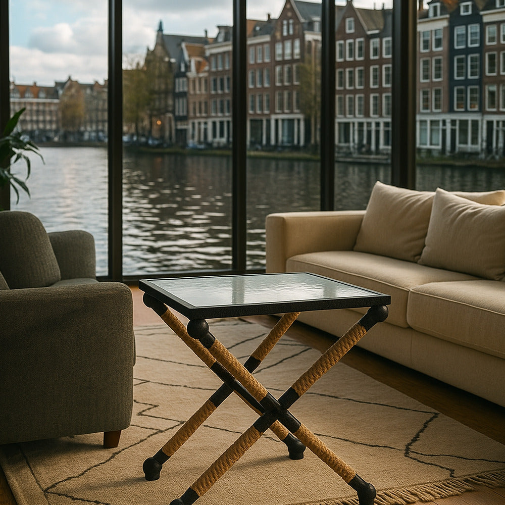Living room with beige sofa, armchair, and coffee table with a view of canal houses.
