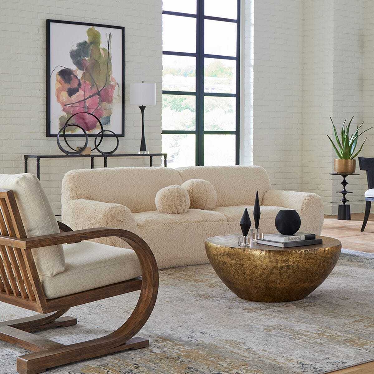 Modern living room with beige sofa, wooden armchair, and round coffee table.